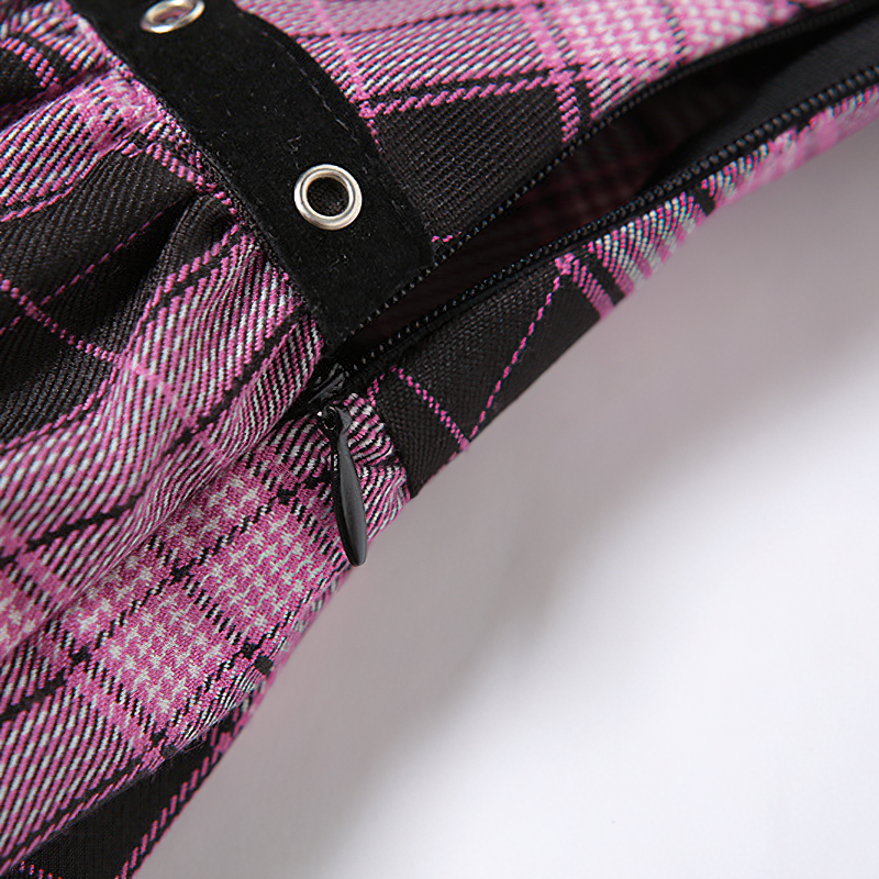 Close-up of the zipper and button detail on a pink and black plaid mini skirt, perfect for gothic outfits.