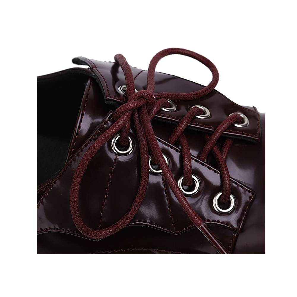 Close-up of trendy dark red punk-style women's shoe with laces and eyelets, showcasing glossy latex leather.