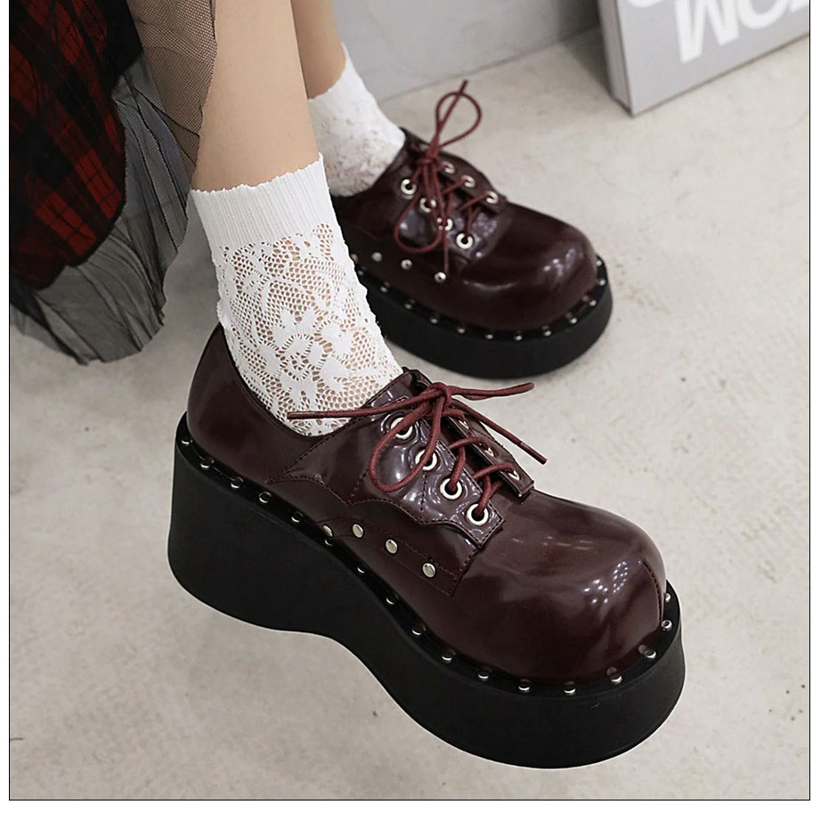 Trendy women's punk platform shoes with lacing and dark glossy finish, perfect for a bold, stylish look.