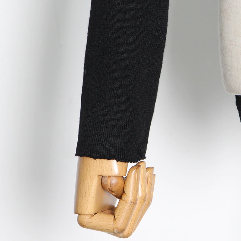Detail shot of a black long sleeve top's cuff on a mannequin, showcasing stylish alternative fashion design.