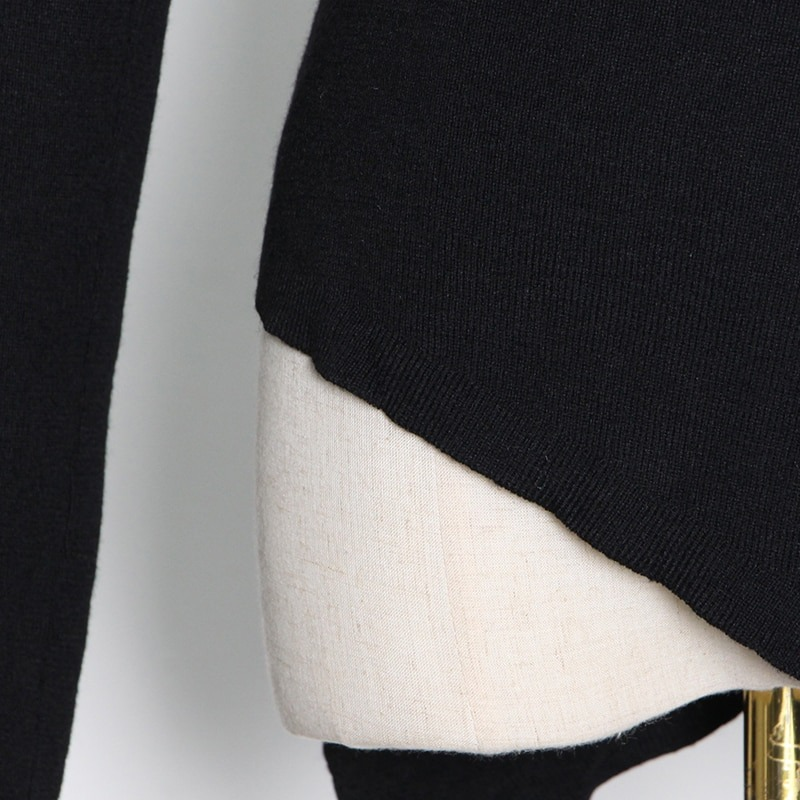 Close-up of black women's slim top with off-shoulder design and stylish hem for alternative fashion lovers.