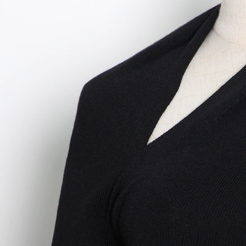 Close-up of black women's slim top with one off-shoulder design, highlighting hollow out details and stylish fabric.