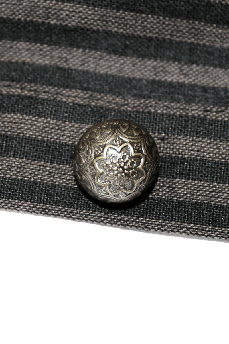 Antique silver button with floral design on striped fabric background.