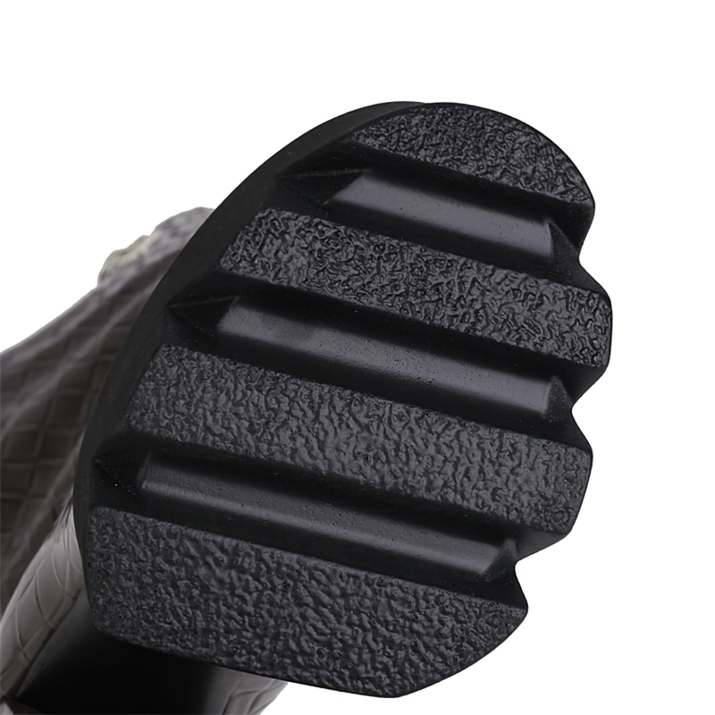 Close-up of the textured sole of women's super high heel platform boots in stylish patent leather.