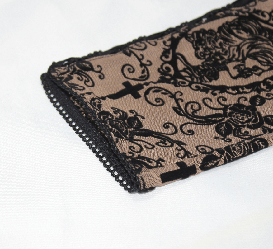 Close-up of elegant gothic leggings with lace trim and intricate black floral pattern, showcasing stylish design details.