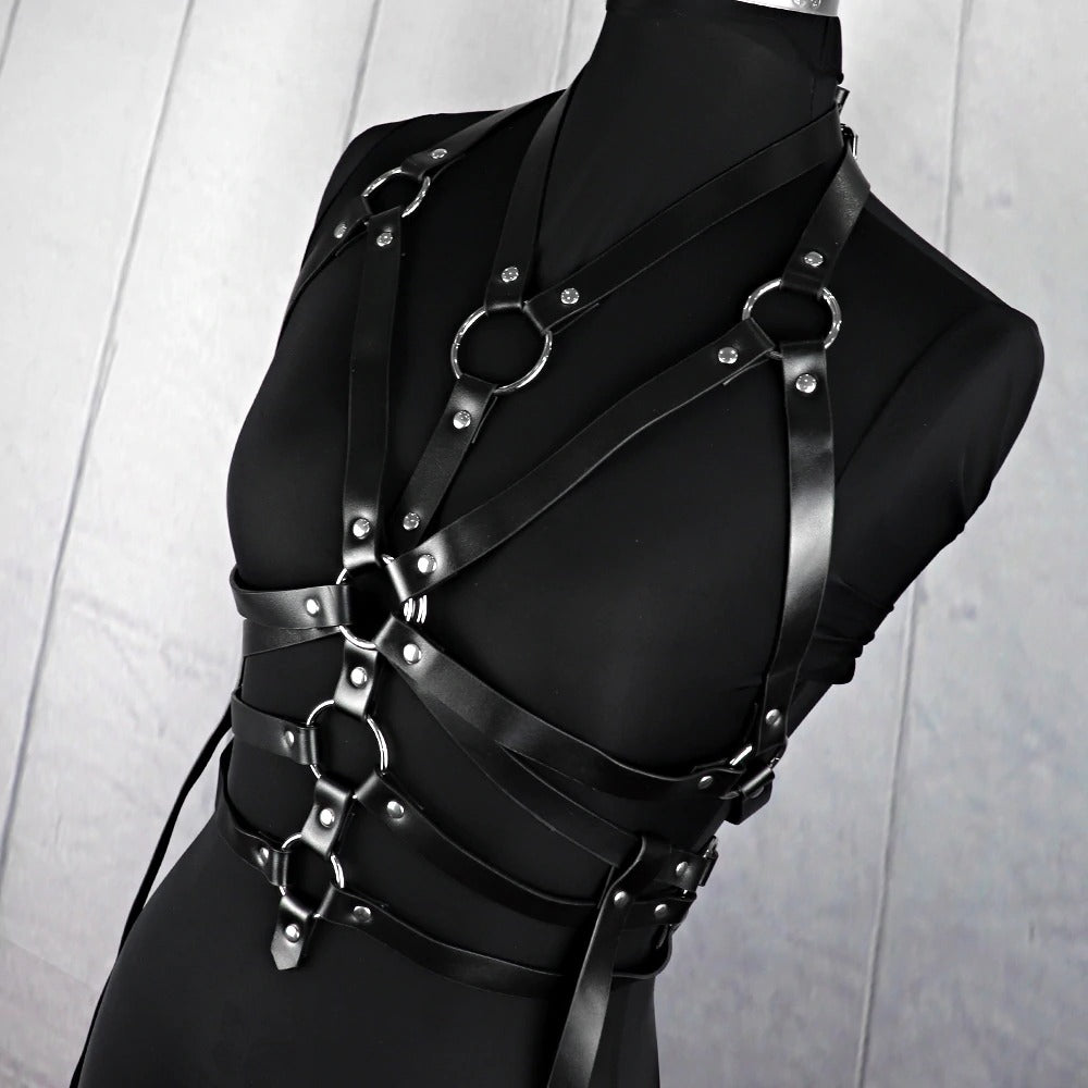 Women's bondage garter belt featuring bold black straps and metal rings for a fierce gothic look.