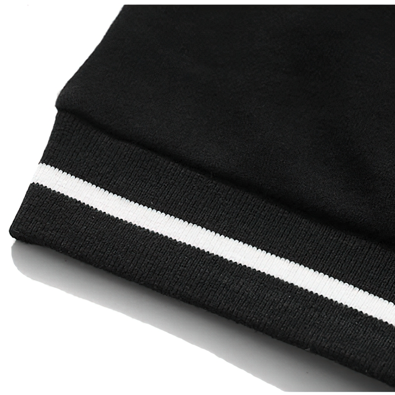 Close-up of the cuff of a women's oversized black sweatshirt featuring a stylish white stripe detail.