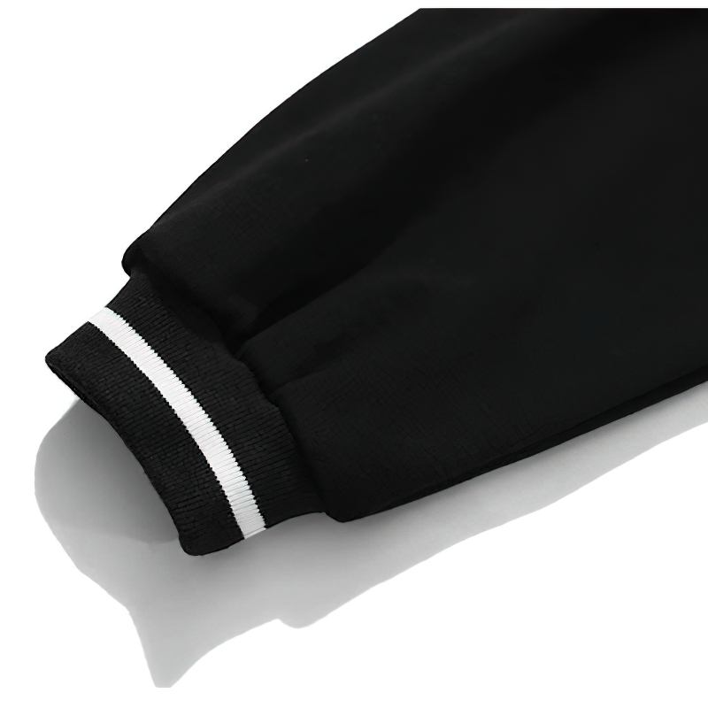 Close-up of the cuff of a trendy women's oversized black sweatshirt with white stripe detailing.