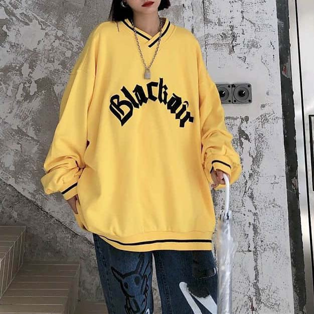 Trendy women's oversized yellow V-neck sweatshirt with 'Blackair' letter patch, perfect for casual wear.