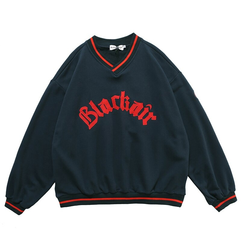 Women's oversized v-neck sweatshirt with letter patch in navy blue and red accents, perfect for casual wear.