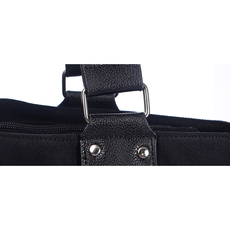 Close-up of the sturdy strap and rivet detail on a black vintage rivet tote bag.