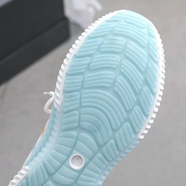 Close-up of blue rubber sole of women's vulcanized sneakers, showcasing flexible tread for enhanced grip.