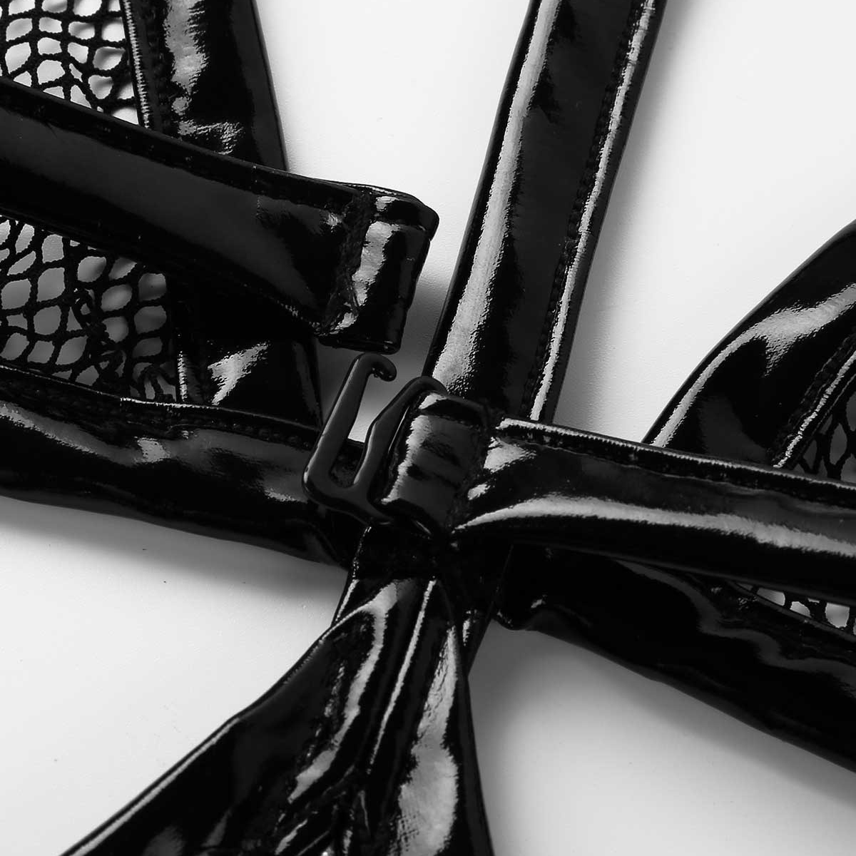 Close-up of the shiny black leather straps and mesh detailing on a women's exotic bodysuit.