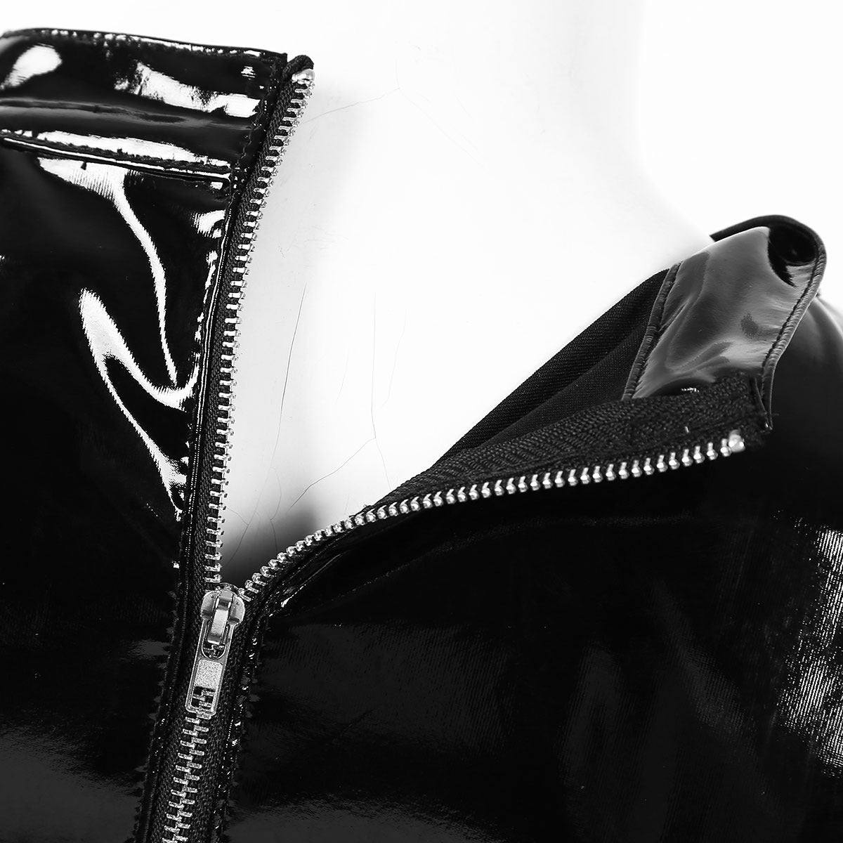 Close-up of the glossy black patent leather zip detail on a gothic crop top, highlighting edgy fashion features.