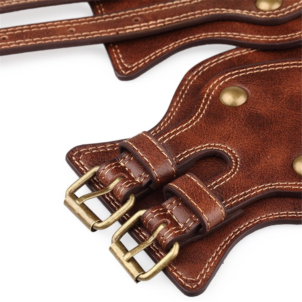 Close-up of women's vintage brown leather belt with rivets and brass buckles, showcasing a trendy retro design.