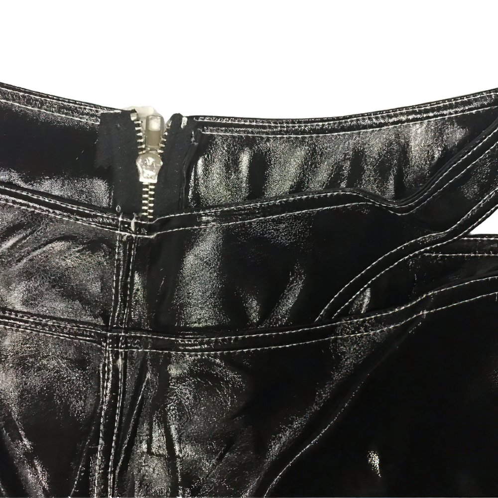 Close-up of women's black PU leather pants showing silver zipper and hollow cut waist detail.