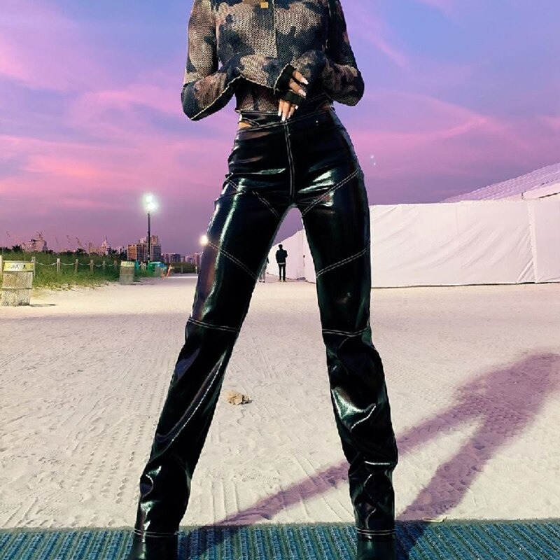 Trendy women's black PU leather pants with hollow cut waist and contrast stitching, perfect for a rock style look.