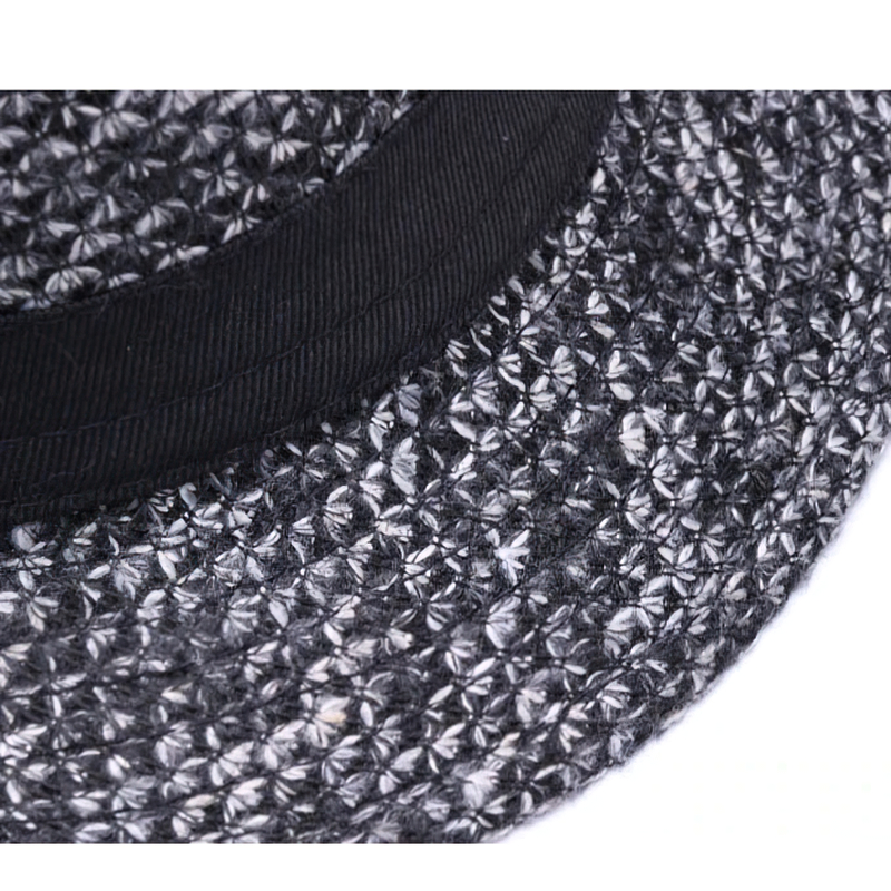 Close-up of a woolen felt fedora hat with a stylish black ribbon band, showcasing textured craftsmanship.