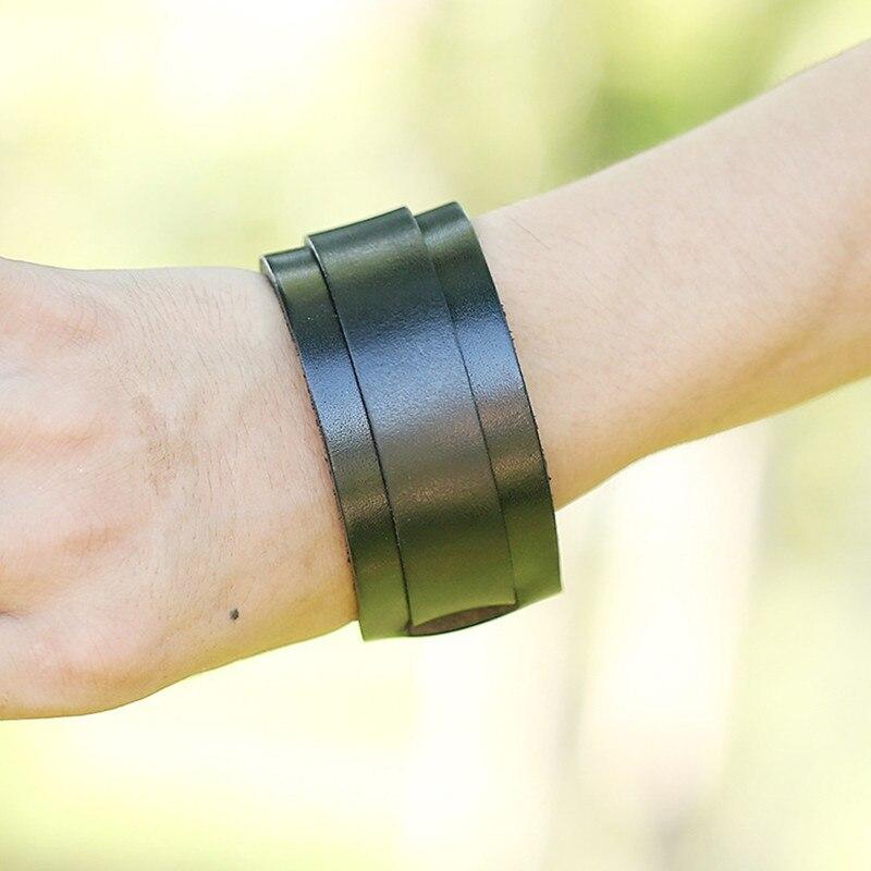 Double wide black leather wristband bracelet worn on a hand, perfect for trendy unisex accessory styles.
